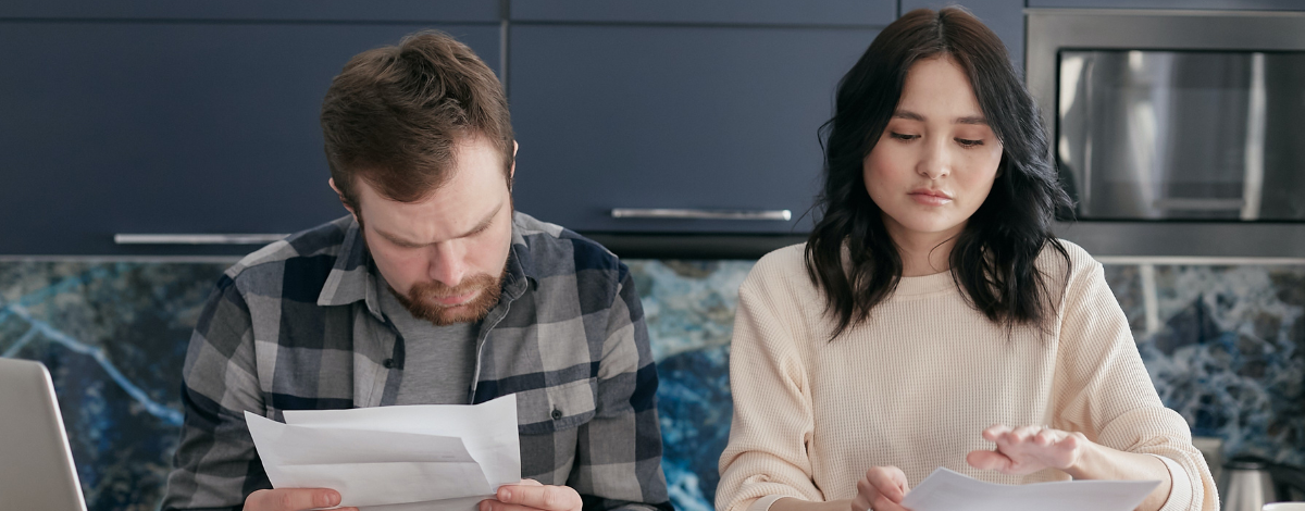 couple holding papers assessing credit card debt
