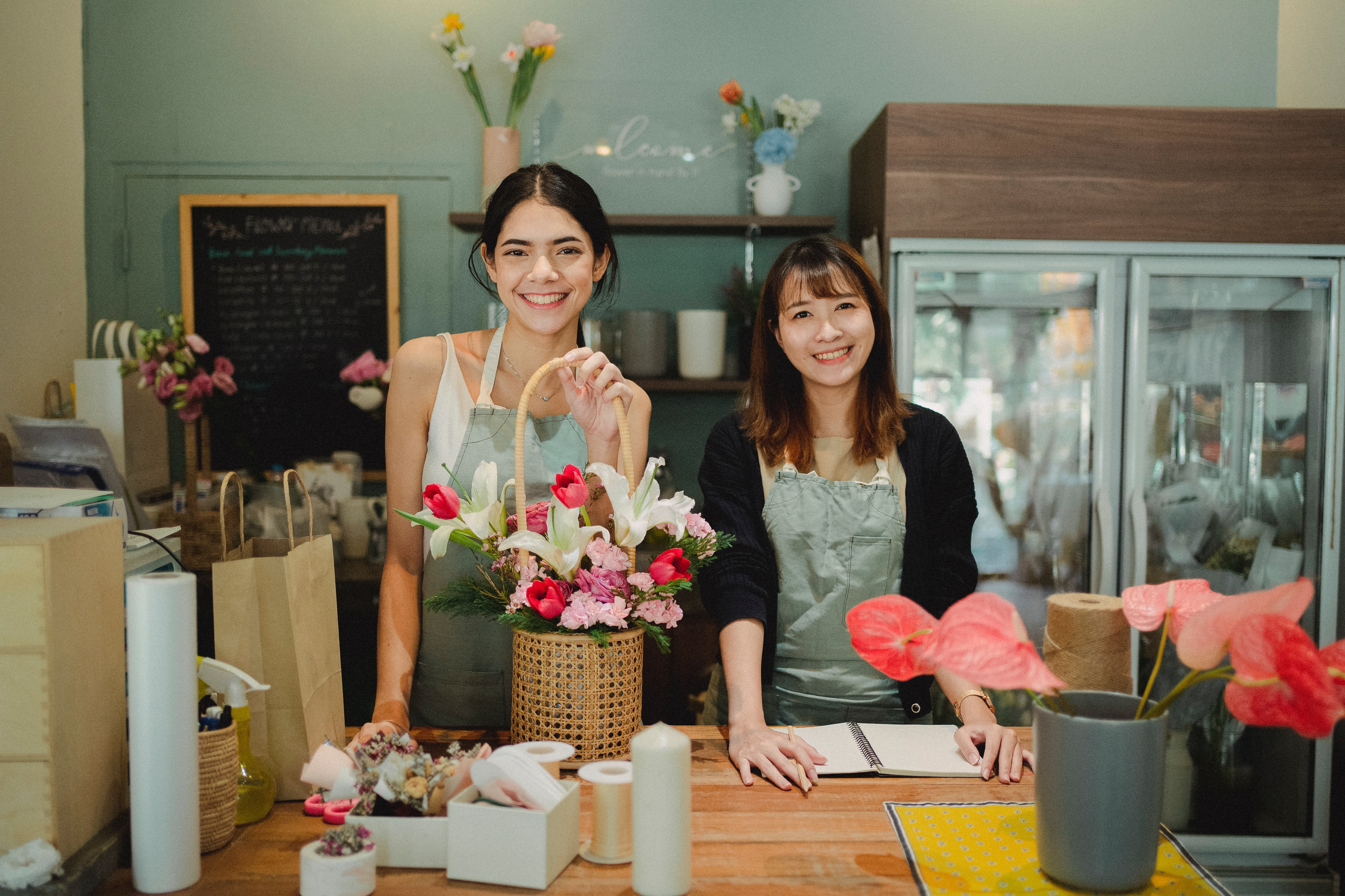 two women at a small business flower shop with a basket of flowers