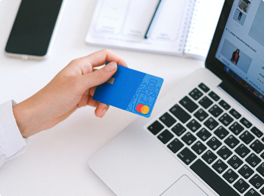 person holding card with laptop