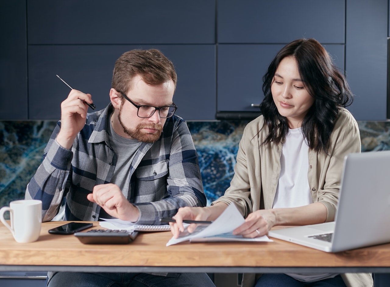 Couple sitting at table looking at documents together