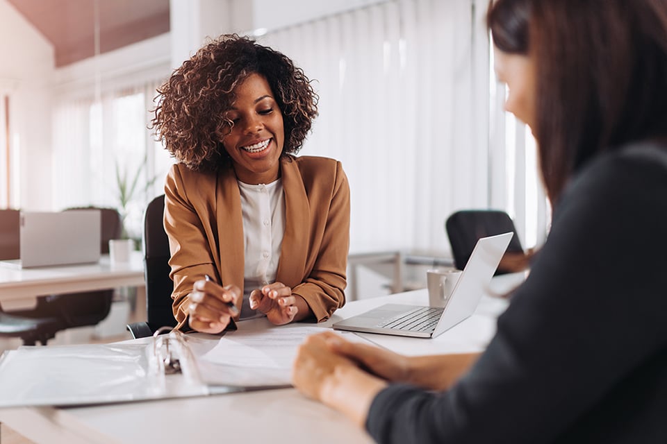 Meeting with smiling woman consulting with another